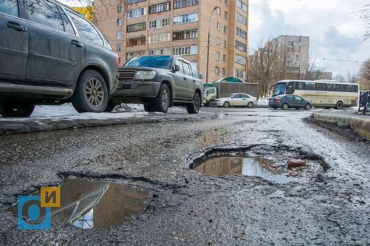 Ямы во дворе. Оттаявшие ямы асфальта. Большая яма во дворе. Ямы в асфальте присыпанные снегом.